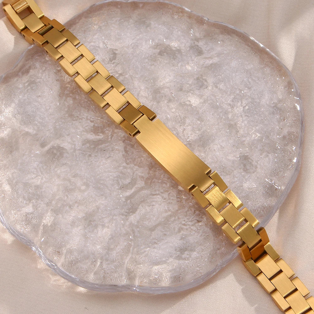 Gold steel link bracelet on a textured surface