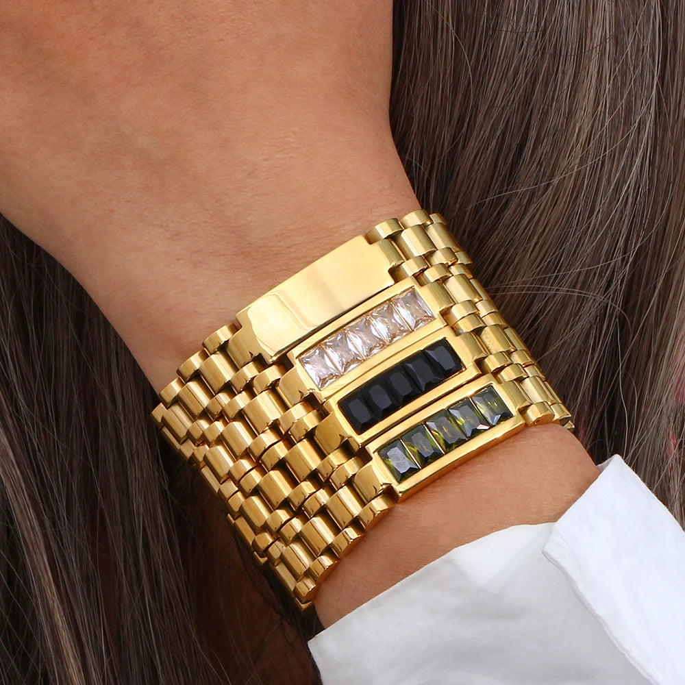 Gold bold link bracelets with embedded stones on a person's wrist