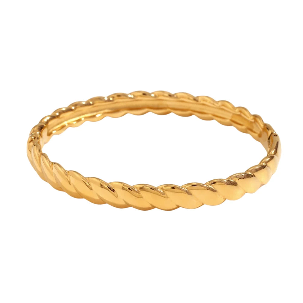 A gold twisted bangle bracelet with a shiny finish.