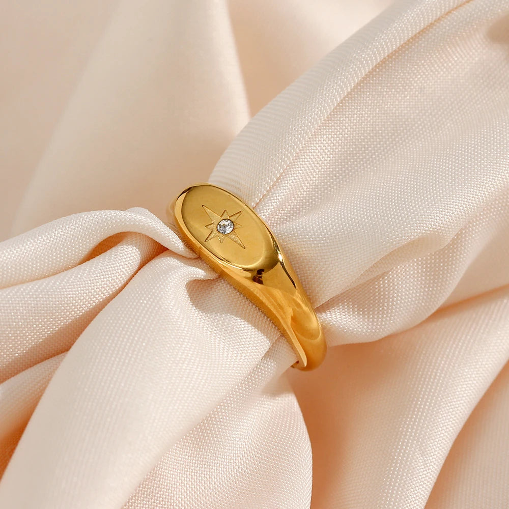 A stainless steel signet ring with a crystal embellishment, 