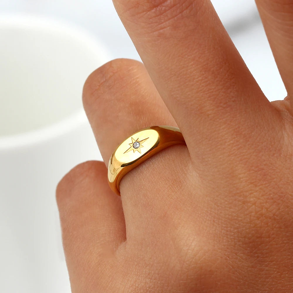 A stainless steel signet ring with a crystal embellishment, on a model's finger