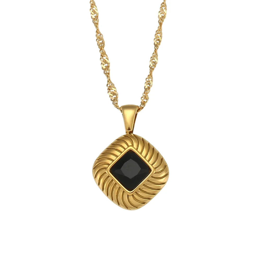 A gold-plated stainless steel necklace with a square pendant featuring a black crystal, on a white background.