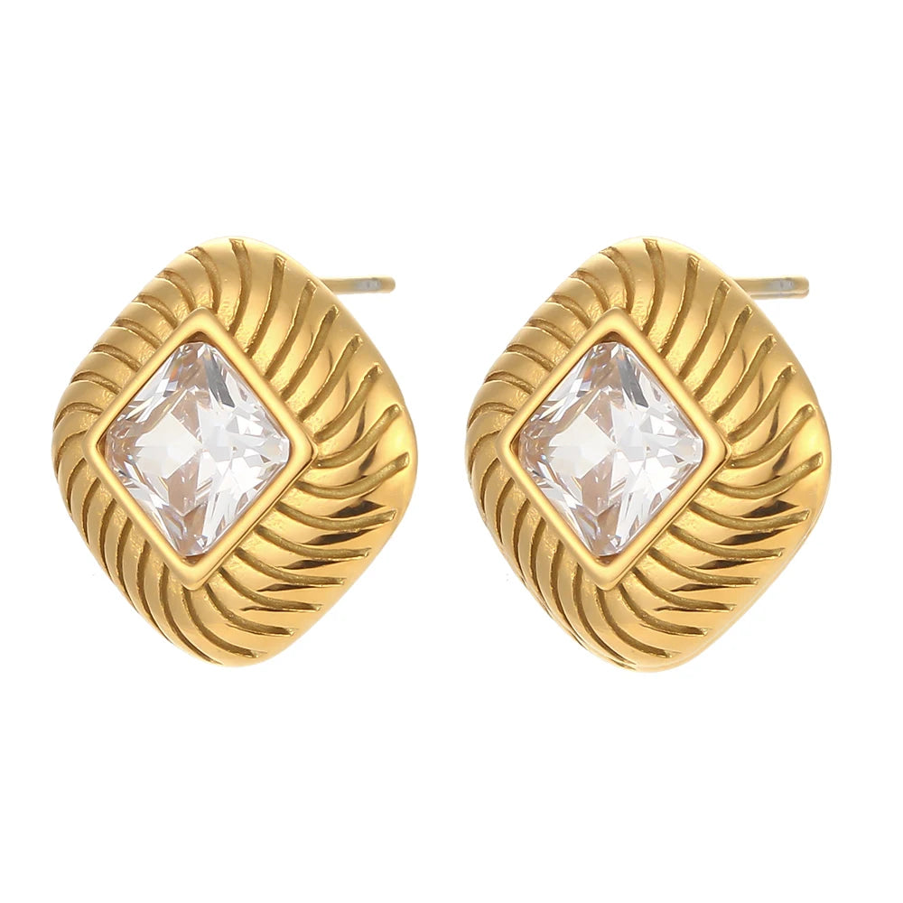 A pair of stainless steel stud earrings with a geometric design and a central clear crystal.
