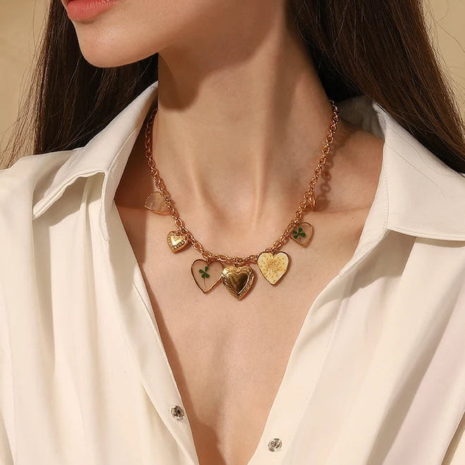 Woman wearing a gold necklace with heart-shaped pendants against a beige background