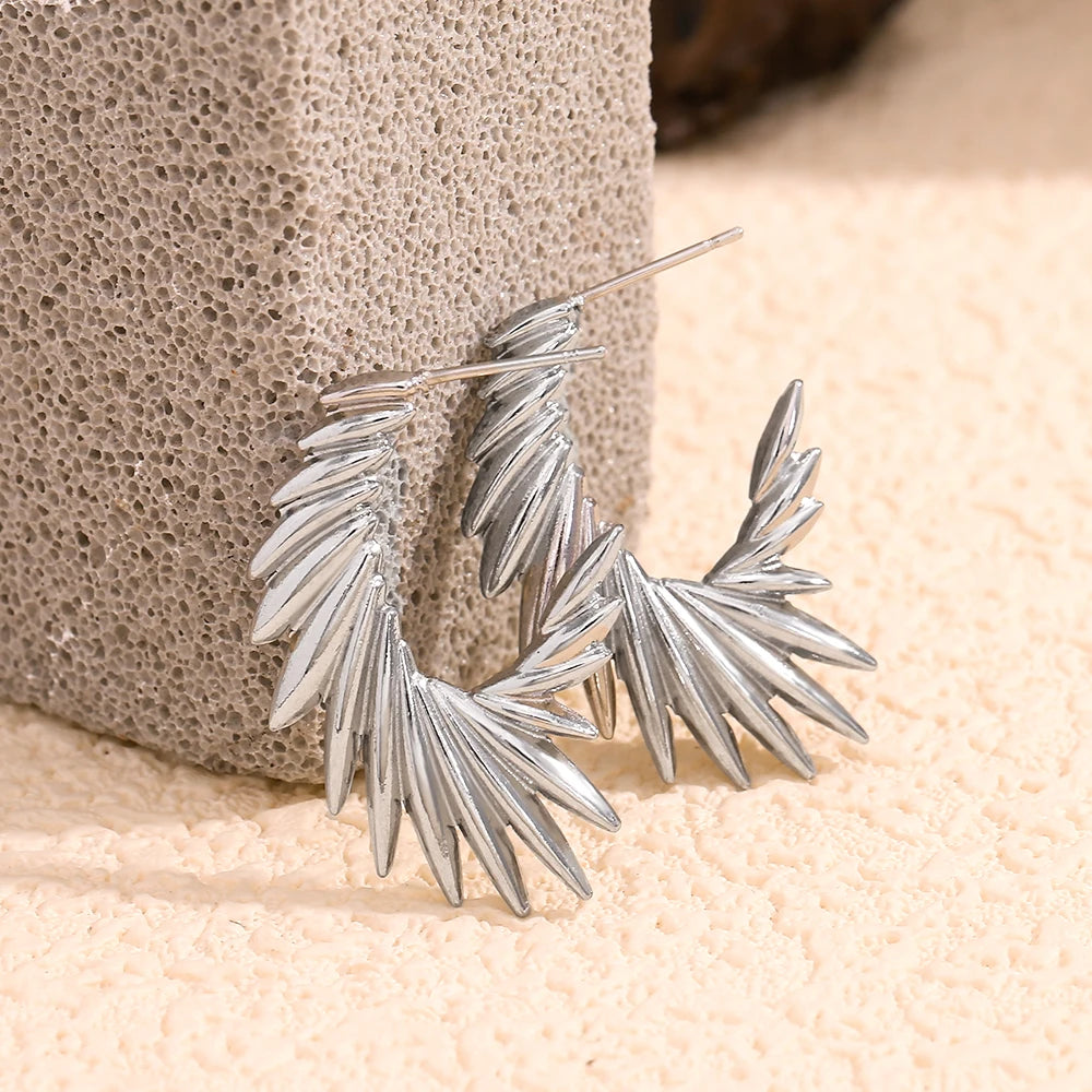 A pair of stainless steel hoop earrings with a textured and spiky design.