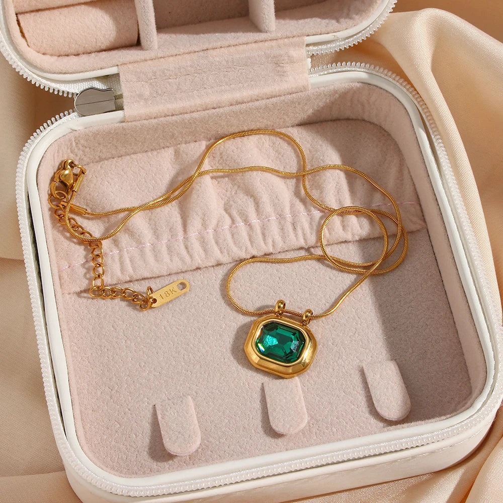 A gold-plated stainless steel necklace with a square-shaped AAA zirconia pendant, displayed in a beige  jewelry box