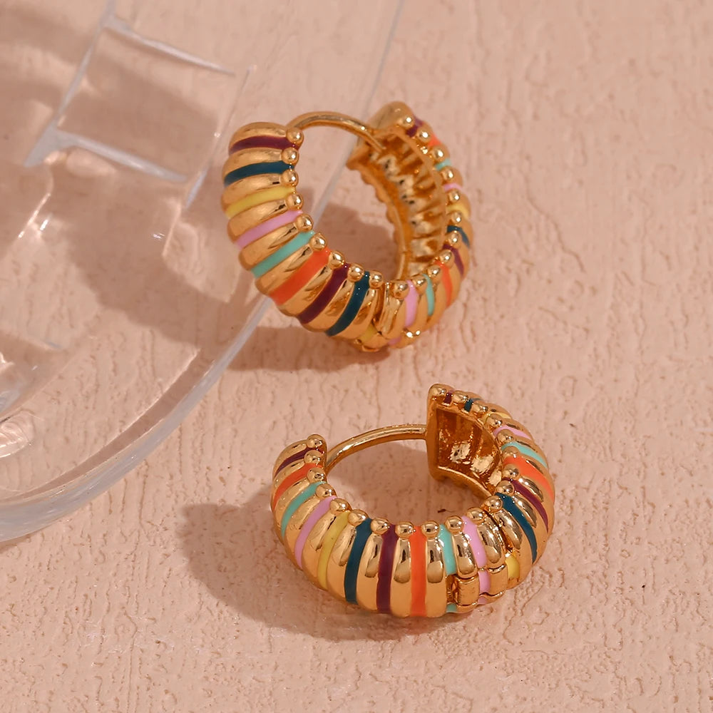 Colorful hoop earrings on a beige surface