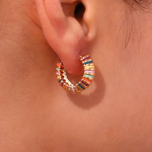 Multicolored hoop earring worn on an ear