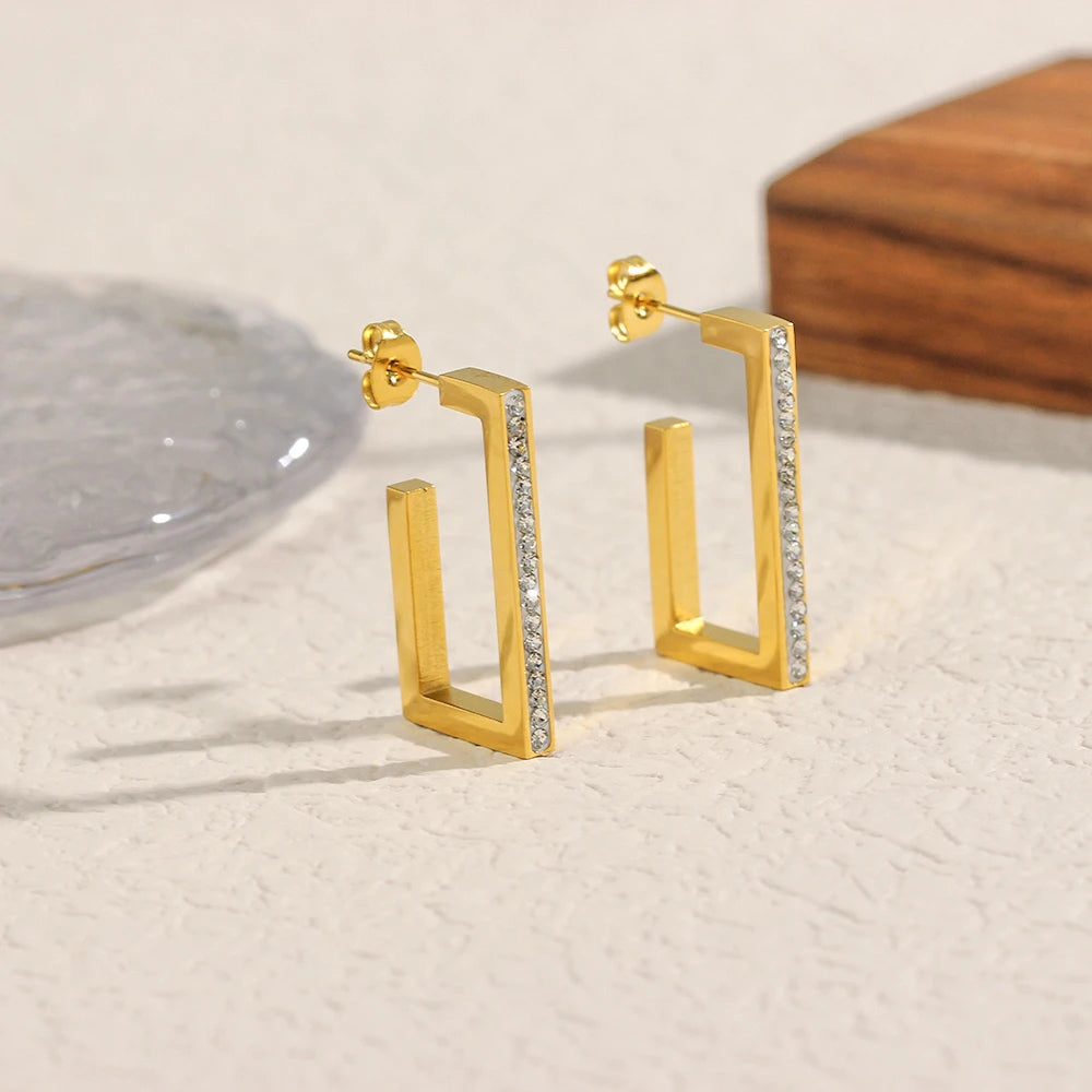 Gold Stainless Steel rectangular hoop earrings with embedded zirconias on a light surface