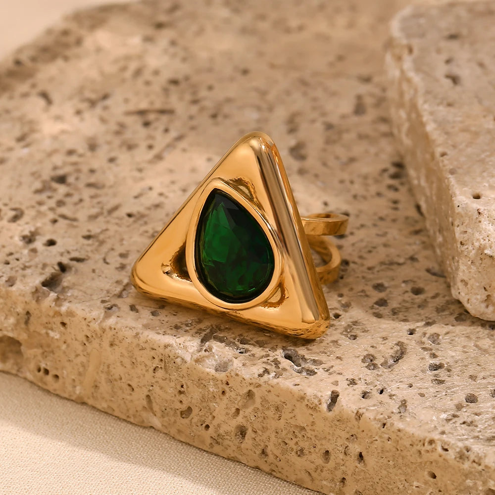 An gold stainless steel ring with a triangular design and a large, green zirconia centerpiece.