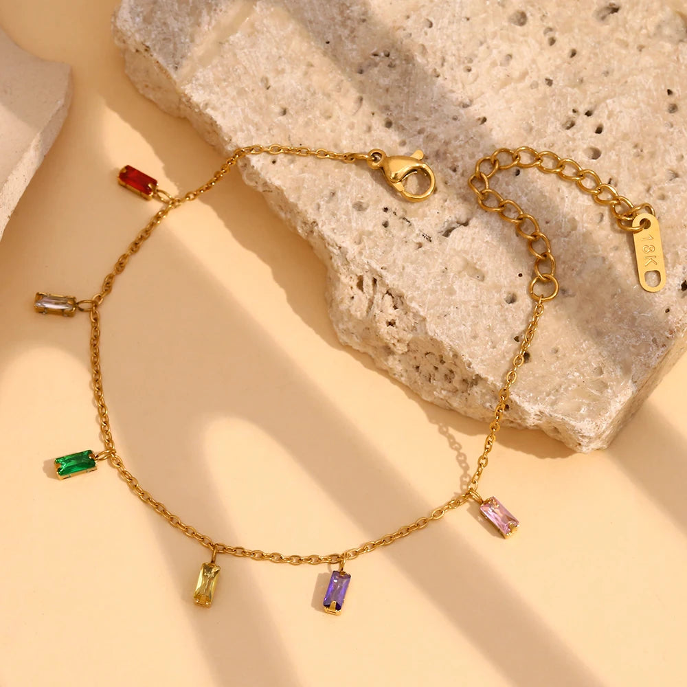 A golden bracelet with multicolored zirconia charms 