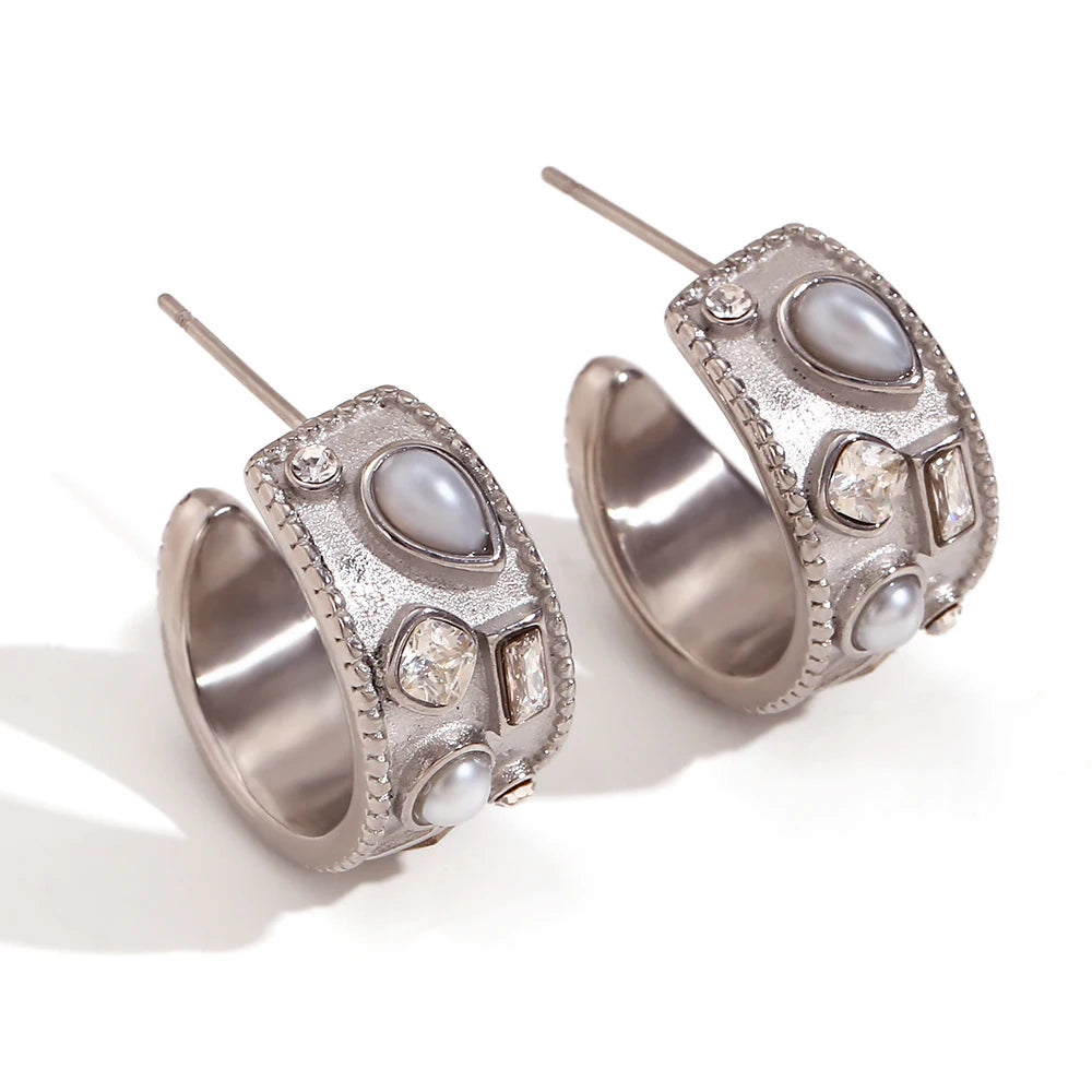 Silver hoop earrings with pearls and gemstones on a white background