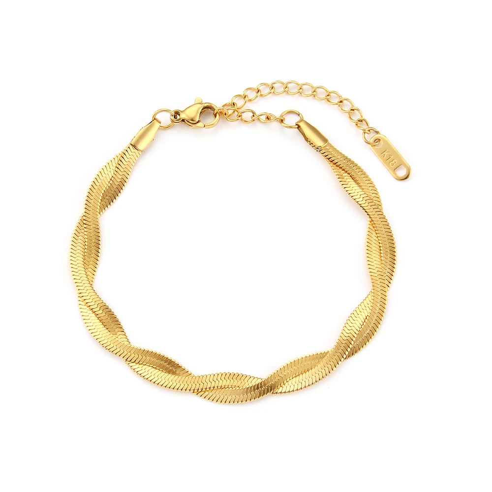 A gold twisted snake chain bracelet flat layed on a white background.