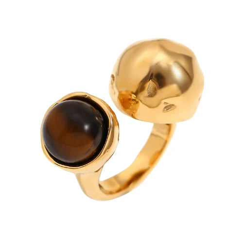 An 18K gold platted ring with a round tiger's eye stone on a hammer textured, asymmetrical band.