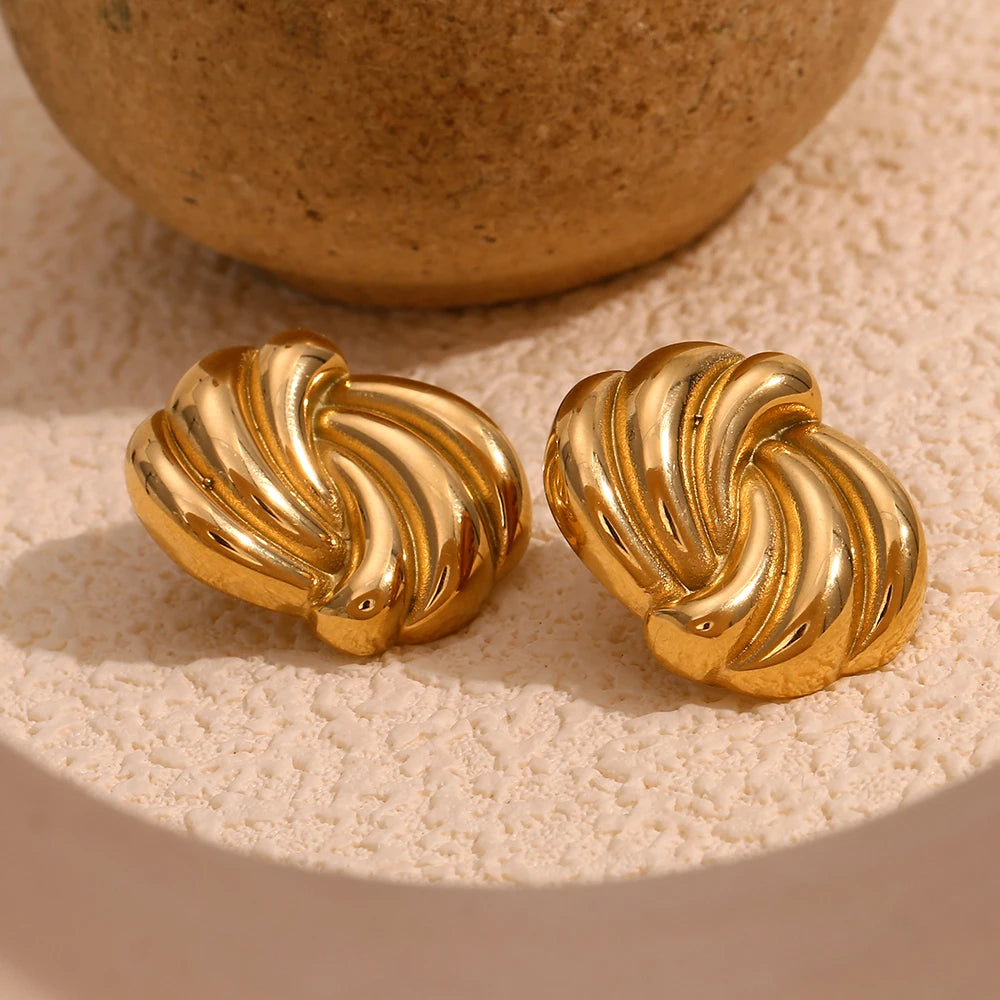 A pair of timeless gold earrings with a twisted design, crafted from 18K gold plated stainless steel displayed